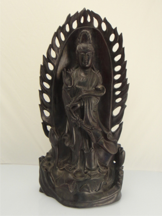Draped in flowing robes and holding a ruyi scepter in her right hand, the Zitan wood figure of Guanyin is placed prominently in front of a fiery backdrop. Majestic at 19 1/2 inches tall, Lot 419 carries an estimate of $2,000-$3,000. Image courtesy of 888 Auctions.